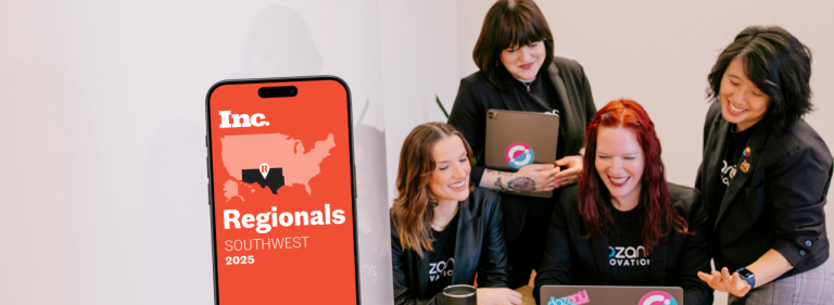 Four women sitting around a laptop wearing black shirts that display "dozanü innovations." To the left is a phone displaying "Inc. Regionals Southwest 2025" over a map of the United States.